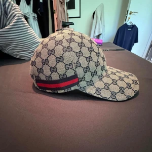 Gucci keps - Säljer en ny Gucci keps som är använd i ungefär 1 månad och är i jättebra skick. Storleken är M. Kvitto, box och dust bag finns.