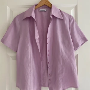 skjorta i satin liknande material - Väldigt fin och t-shirt skjorta i satin material som har en fin passform då den faller fint längst sidan!, endast använd en gång och inga defekter förekommer 