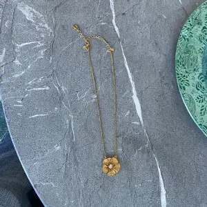 ett superfint guldhalsband från pilgrim som inte går att köpa nytt, en fin rosa sten i mitten och halsbandet är ungefär 50 cm långt och justerbart, blomman e ungefär 2x2 cm🤩