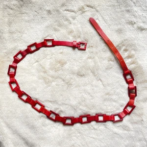 Rött läderbälte  - Ett supersnyggt rött läderbälte i riktigt bra skick! Köpt second hand men aldrig använd, den perfekta accessoaren!