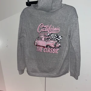 Hoodie med tryck - Hoodie med tryck på ryggen, köpt i sommars typ och använd några gånger