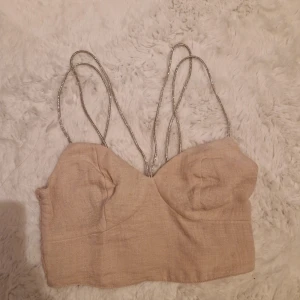 Glittrig topp - En jättesnygg babyrosa festtopp med glitterstraps. Passar både XS och S. Har haft den ca 2 gånger och skulle säga den är som ny.