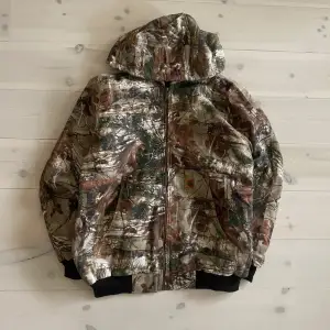 00s vintage Carhartt real tree camo work jacket - L/XL  Storlek XL sitter som L/XL  Mått Pit to pit 64cm Shoulder 50cm Total length 76cm  Notera att detta är en reworked jacka!Vilket betyder att det är andra tyger som är ihopsatta till en ny carhartt