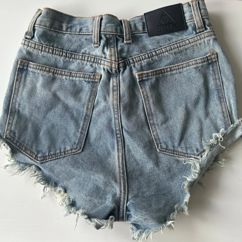 UNIF jeansshorts i mini modell, såååå coola och unika!! sitter highwaist, felfritt skick. står storlek 27, skulle säga XS-M. . Shorts.