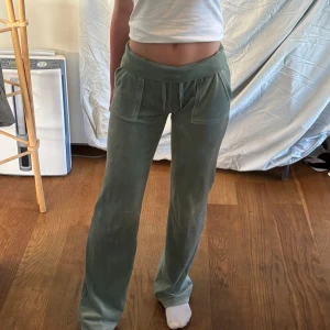 Gröna mjukisbyxor - Ett par gröna Juicy Couture. Byxorna har snörning i midjan och fickor fram och bak med knappdetaljer.