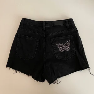 Jeansshorts med fjäril i strass - Svarta jeansshorts med strassfjäril på bakfickan 🦋 