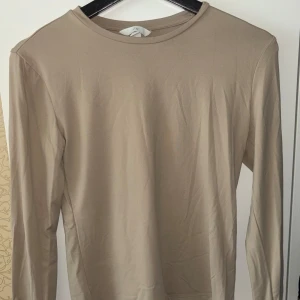 Mikrofiber topp - Mikrofiber topp i beige från H&M i storlek M. Använd fåtal gånger, helt nyskick. Köptes för 149:-, säljer för 70:-.
