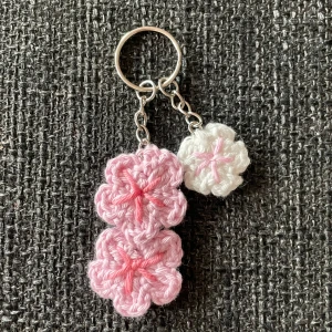 Virkad nyckelring med blommor  - Handvirkad nyckelring med rosa blommor. Kan göras i andra färger, skriv dm! Skriv även för mer bilder eller mått!