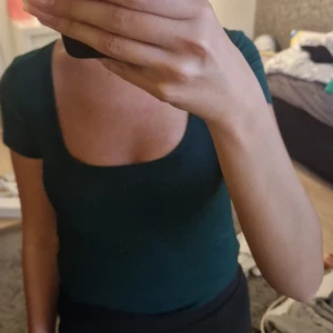 Grön topp - Mörkgrön topp med urringning. Jätteskön, ser lite skrynklig ut när den hänger men inget som syns när man tar på sig den. Aldrig använd, lapparna kvar💚