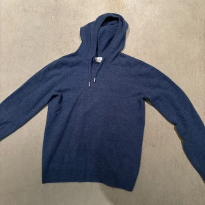 Merinoull hoodie - En snygg hoodie gjord av merinoull men ser ut som Kashmir. Den är ifrån Ahlquist clothing och är i typ nu skick. Den är endast använd ett fåtal gånger och har inga tecken på att den är använd 