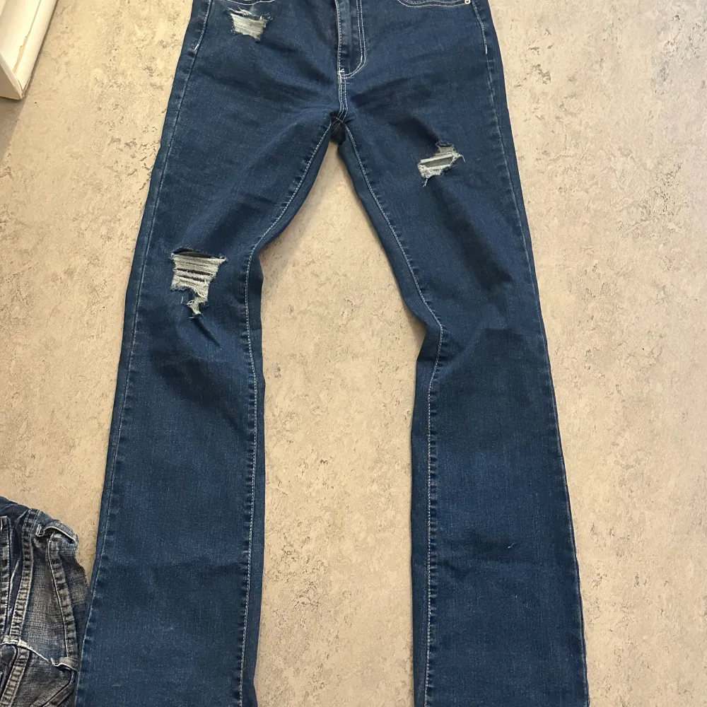 Mörkblå jeans som är low/mid waist med slitningar skulle gissa storlek 36 De är stretchiga. Jeans & Byxor.