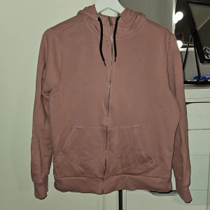 Etriel huvtröja ny - Ny rosa huvtröja med dragkedja. Tröjan har två fickor framtill. Se sista bild för rätt färg. Katt finns I hemmet