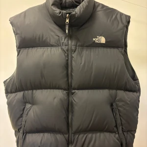 The North Face väst - Dunväst från The north face, sitter som L/XL. Skick 9,5/10. Nypris1500kr, mitt pris 299. Även öppen för byte