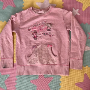 Rosa mezzo piano tröja (140 cm) - Säljer för att jag jag tröttnat på den och det inte är min stil längre. Använd ett par gånger. Den har en fläck på armen. Passar mig och jag är 166cm. Kontakta om du har frågor, köp är på!