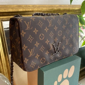 Väska - Den har tappat knappen där fram men går fortfarande att öppna och stänga som vanligt 