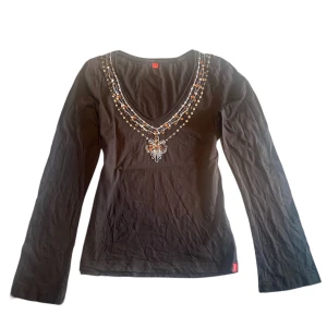 Bohemisk långärmad  - Säljer denna unika bruna långärmade tröjan i bohemisk stil med underbara diamanter, pärlor och paljetter vid halsringningen. Tröjan är från Espirit o är i mycket bra skick med alla stenar kvar🥰 Skriv privat vid intresse o frågor🫶🏻 Köp nu går även bra😊