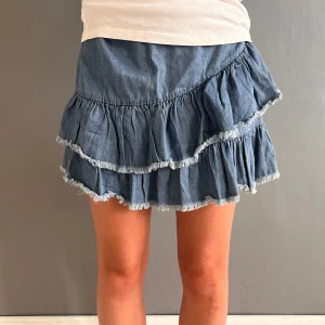 Volang jeanskjol - Superfin volang jeanskjol som är väldigt eftertraktade just nu. Säljer min favorit kjol som är i perfekt sick. Finns en dragkedja i midjan man stänger den med. Skriv om ni har några frågor eller vill ha fler bilder❤️❤️❤️