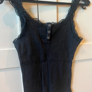 Linne med spets - Säljer detta svarta linne från Hollister i storlek XS. Den är i fint skick men säljer pga att den är för liten. Köparen står för frakten.