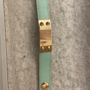Armband - Turkist armband med guld detaljer. Finns två knappar så passar både folk emd större och mindre armleder. 