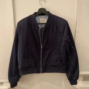 Mörkblå bomberjacka - Jättesnygg bomberjacka som är perfekt till våren och hösten! Säljs på grund av att den inte kommer till användning
