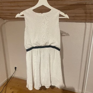 Vit klänning  - En fin vit sommar klänning med ett svart resårband i midjan, storlek 146. Side material och lite randig. ☺️