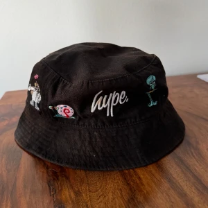 Buckethat - En välanvänd buckethat med svampbob motiv. Konstig mörkbrun färgning på hatten. Inte så mycket men finns absolut där! 