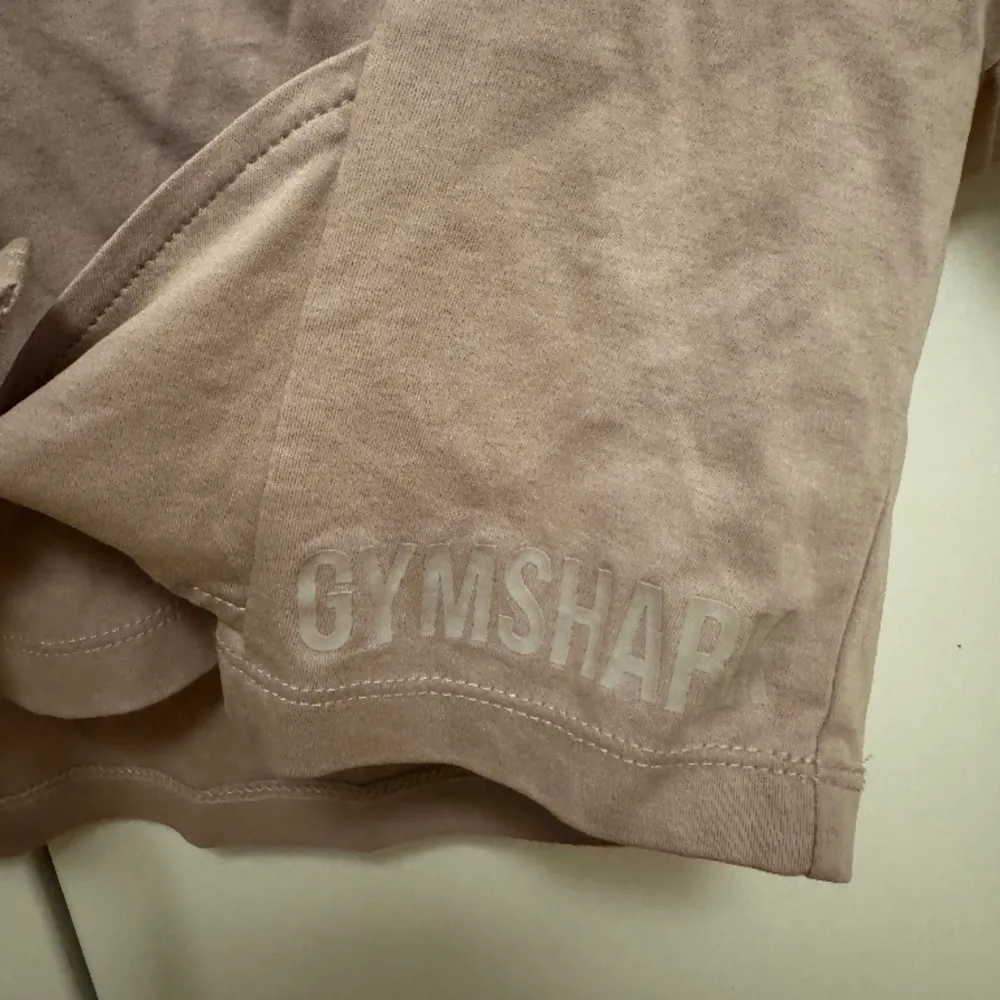Aldrig använd croppad t-shirt från Gymshark! Två band man knyter åt u midjan och fina detaljer på hela tröjan! Gymshark loggan på ena sidan. . Toppar.