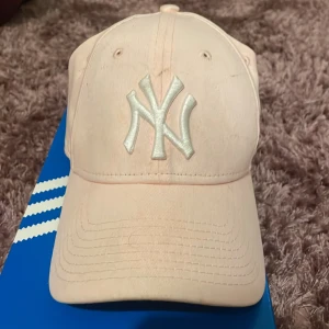Newyork yankees keps - Kepsen är lite smutsig men i bra skick. Den är lätt ljusrosa :) köp gärna med köp nu!
