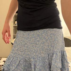  Jättefin blå blommig kjol som nästan aldrig är använd. Säljer då den inte riktigt är min stil. Midjemåttet rakt över är 31 cm men stretch på baksidan, se bild. Storlek 134, från Lindex. 