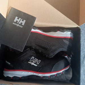 Oanvända i kartong - Helt oanvända arbetsskor från HellyHansen. Extra mjuk sula för bästa komfort. Kolla gärna upp modell och pris själv för bästa info. Köparen står för frakten.
