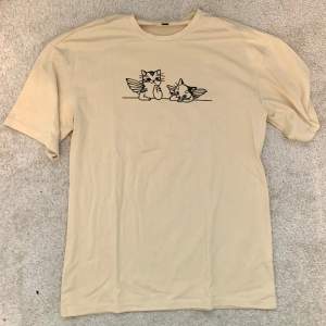 T-shirt med katt tryck i storlek s!! Däremot är den oversized och känns typ som L☺️ Materialet är skönt och beige :) Om ni har frågor är det bara att fråga <3⭐️ 