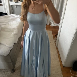 Balklänning  - Klänning som användes när jag slutade 9an. Ljusblå i sidenmaterial och passar folk som är runt 170 långa. Den är skräddarsydd och mina mått är: midja 65cm, höfter 98cm, byst 88cm. Den har några enstaka smutsfläckar längst ner, skriv för bilder.