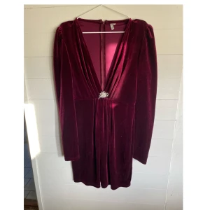 Klänning - Julig klänning med djup ringning och smycke, använd kanske en gång! Från Nelly i storlek 40.