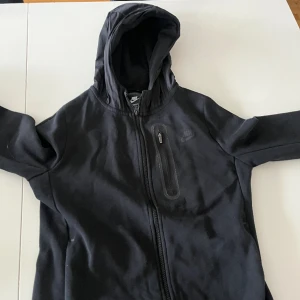Nike tech luvtröja  - En svart Nike tech woowen luvtröja i storlekn XL i BARNSTORLEK. Den är i bra skick 