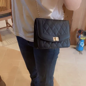 Handväska - Svart handväska💕säljer då jag inte använder! 💕 Kedjan har tappat lite färg därav billiga priset. Köpte från shein för ett tag sedan för 109 kr! 💵 Kedjan är ganska lång! Skriv för för bilder eller funderingar!💕 Pris kan självklart diskuteras!💕💕