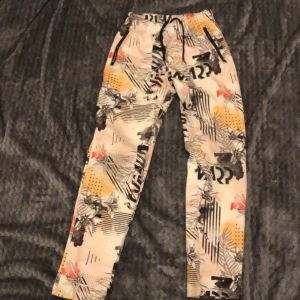 Byxa - Byxor med rött och gult mönster och svarta detaljer 