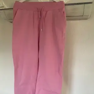 Mjukisbyxor i sweatshirt-material i rosa från NLY Trend (Nelly.com). En ”oversize” modell med resår samt dragsko i midjan och två fickor framtill. Ribbad mudd i midjan samt benslut. Fint skick.