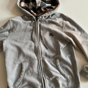Burberry zip hoddie - Säljer denna skit snygga burberry zip hoddie i storlek l sitter som m/l  !äkta! Pris kan diskuteras Obs. Lite tvätt blek