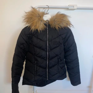 Svart vinterjacka  - Storlek: 160 (barn) Avtagbar luva i fuskpäls.