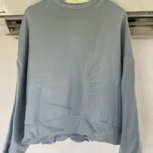 Ljusblå sweatshirt i en oversized, rak modell från Nelly.com (deras ”got it sweat”). Ribbade muddar i ärmslut, halsring samt nedtill. Fint skick.