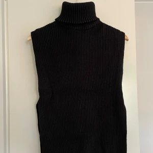 Väst med polokrage - Värmande väst med slit i sidan. Bra passform på polokragen, blir ej säckig efter användning. Passar storlek S/M.