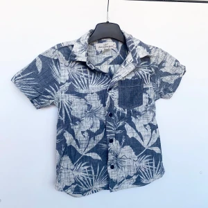 Skjorta barn  - Kortärmad skjorta för barn i storlek 116. Marinblå knappar och en bröstficka 