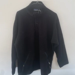 Patagonia fleece - Säljer en svart Patagonia fleece i strl M (funkar unisex). Något oversized fit, inte jätteanvänd men har några mindre fläckar. Har varken använt eller tvättat den personligen men ganska säker på att dessa går bort i tvätt.
