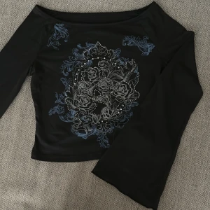 Y2k tröja med rhinestones - Skitsnygg svart tröja med stora ärmar och tribal symboler med rhinestones på, säljer för jag använder den inte💕