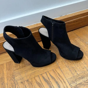 Klackar med öppen fot - Tjockare klackskor storlek 39, öppen fot och vid tårna. Använda så har lite skrapsår men inget som syns, ena dragkedjan har dock tappat metall grejen som man öppnar med, men själva dragkedjan på den funkar ändå. Superfina🌸