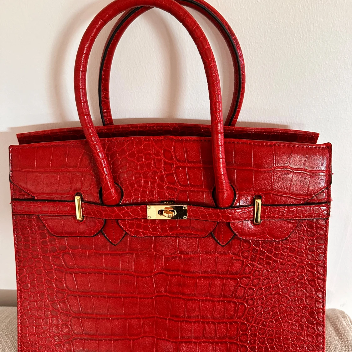 Röd handväska i krokodilmönster