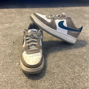 Nike Airforce 1 athletic club - Snygga skor som passar till allt.  Nypris: 2300kr. Använda många gånger så dem är i ett användt skick. Det finns ett hål vid sidan(se bild) och 2 hål inuti skon men annars i okej skick. Hör av er vid frågor och funderingar. 
