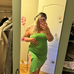 Grön klänning från Shein - En grön klänning från Shein med en åtsittande passform. Klänningen har en slits på sidan och är ärmlös. Den har en enkel design med rynkade detaljer på sidorna. Endast provad. 