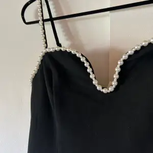 Svart kort klänning med pärl detaljer perfekt för fest. Endast använd en gång så i väldigt bra skick🌸köpt för 399kr