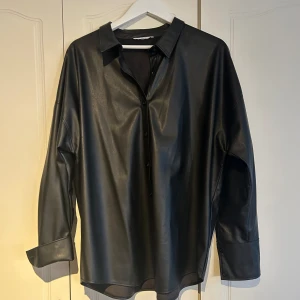 PU skjorta - Fake skinn/läder skjorta, något tjockare tyg, fungerar som overshirt. Aldrig använt, oversize i modell.